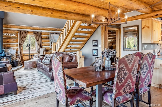 795 Zebulon St, Alma, CO 80420 - dining area featuring log walls, plenty of natural light, light wood-style floors, beamed ceiling, and a wood stove