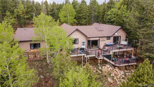 11094 Thomas Dr, Conifer, CO 80433 - rear view of house featuring a wooden deck, a forest view, and a shingled roof