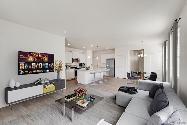 living room with hardwood / wood-style floors and a notable chandelier