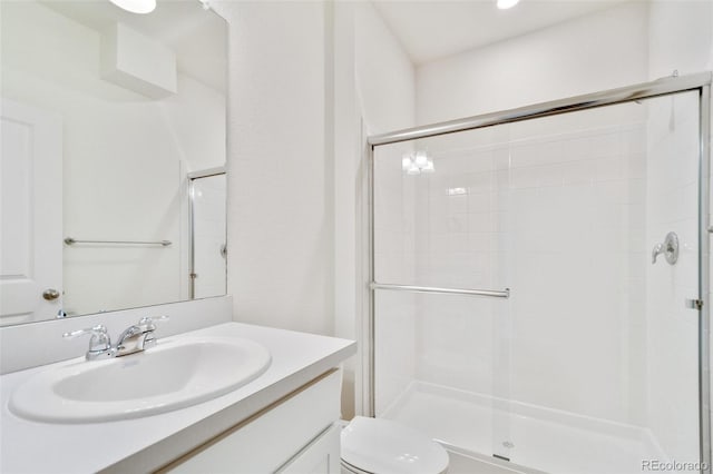 bathroom featuring an enclosed shower, vanity, and toilet