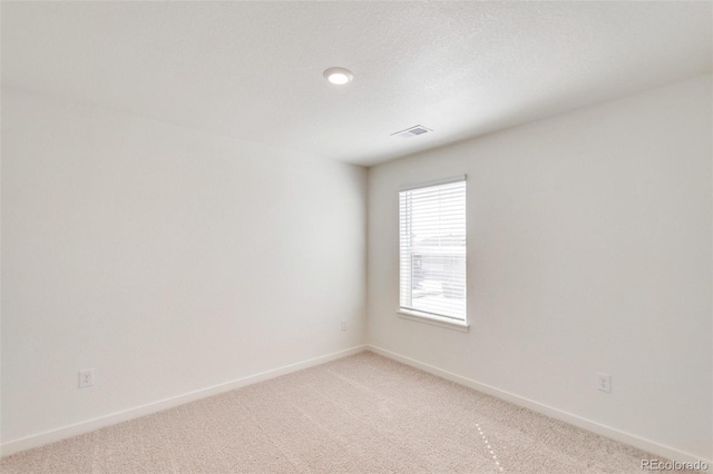 carpeted empty room with a textured ceiling