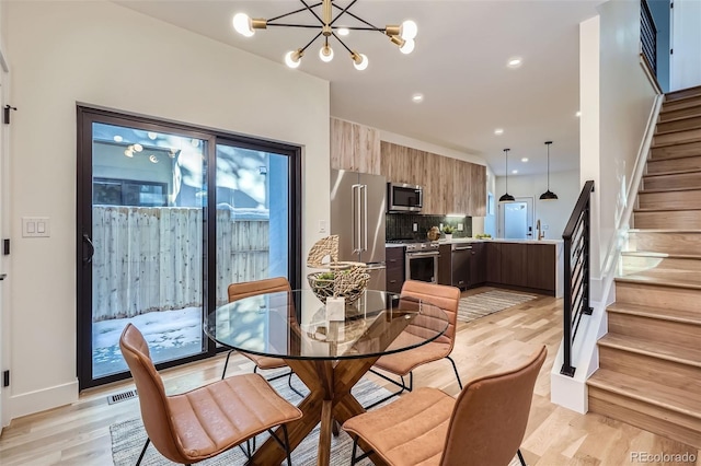 dining space with a chandelier and light hardwood / wood-style flooring