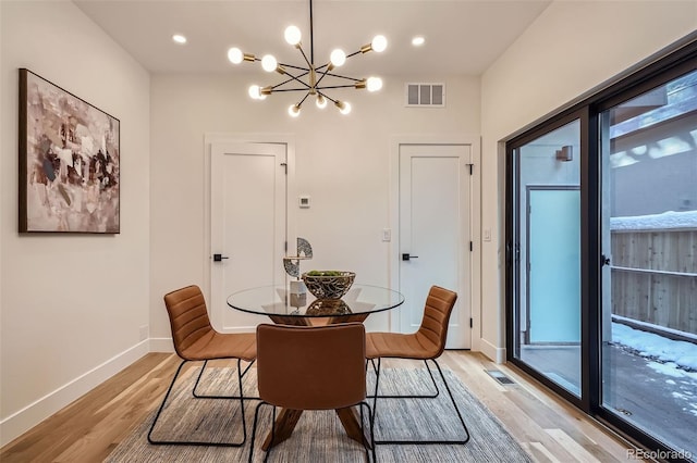 dining room with a chandelier and light hardwood / wood-style flooring