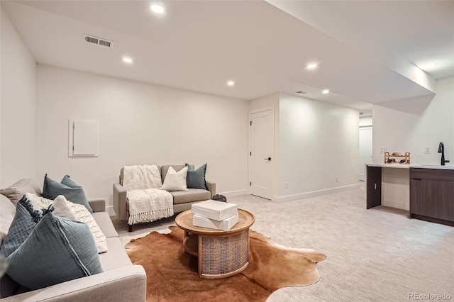 living room featuring sink and light colored carpet