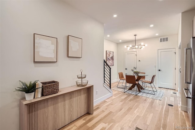 interior space featuring a notable chandelier and light hardwood / wood-style flooring