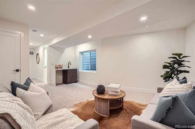 carpeted living room with sink