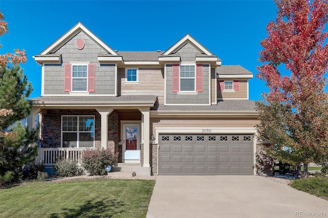 view of front of property featuring a front lawn, a garage, and covered porch