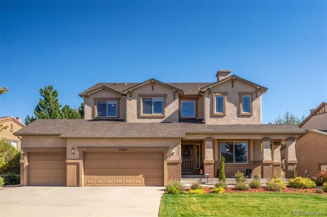 view of front of property with a garage and a front lawn