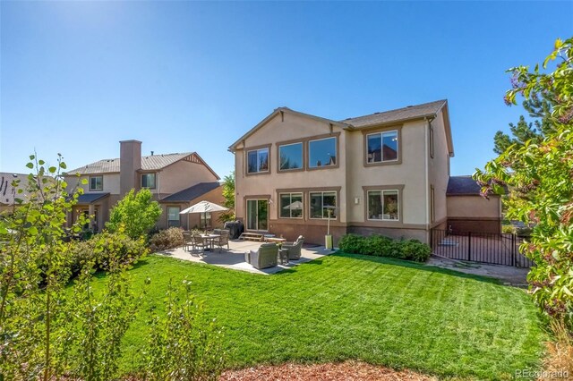 rear view of house with a lawn and a patio area