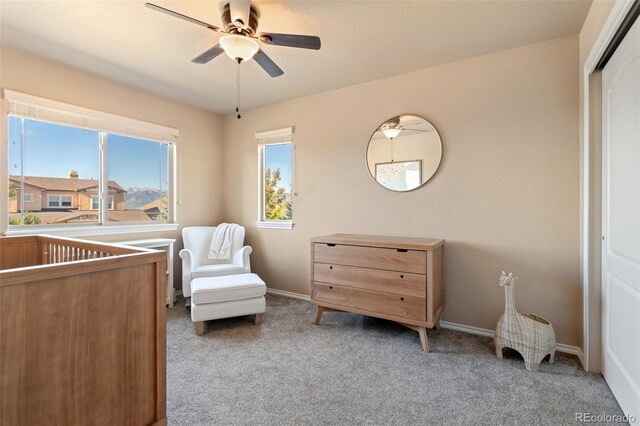 sitting room with ceiling fan and light carpet