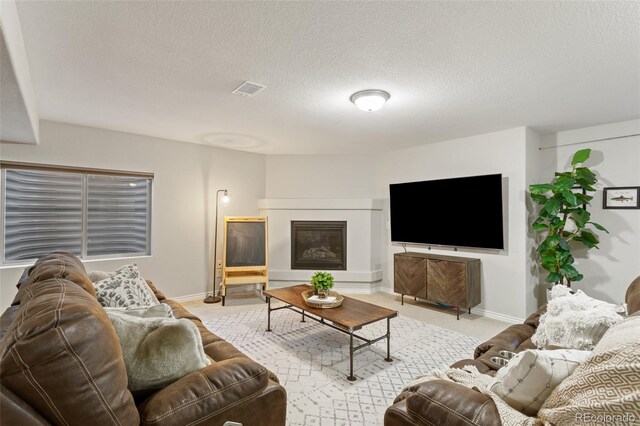 carpeted living room featuring a textured ceiling