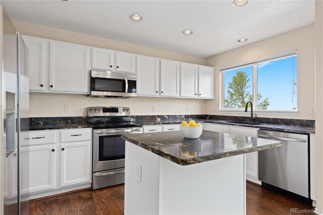9719 Burberry Way, Highlands Ranch, CO 80129 - kitchen featuring stainless steel appliances, a sink, white cabinetry, dark stone countertops, and recessed lighting