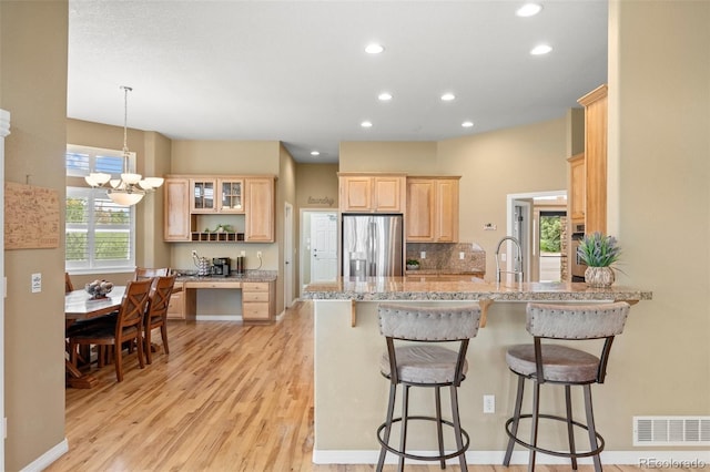 1251 Double Eagle Ct, Castle Rock, CO 80104 - kitchen featuring stainless steel fridge with ice dispenser, light brown cabinets, a peninsula, recessed lighting, and light wood-style floors