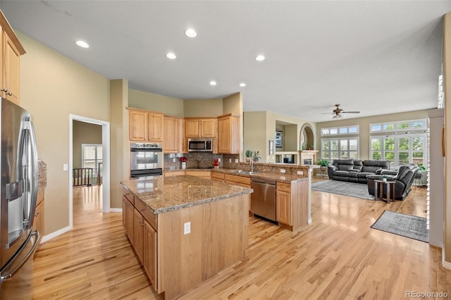 1251 Double Eagle Ct, Castle Rock, CO 80104 - kitchen with stainless steel appliances, light wood-style flooring, a peninsula, a center island, and recessed lighting