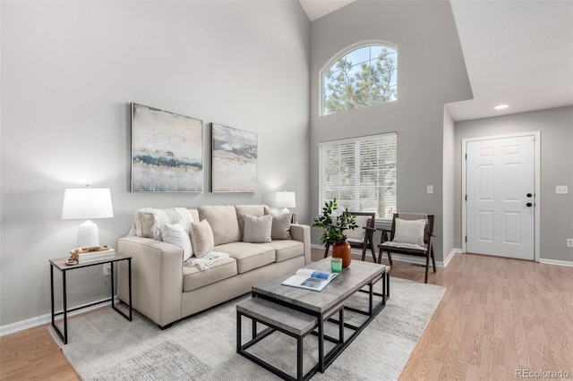 living room featuring light hardwood / wood-style flooring and high vaulted ceiling