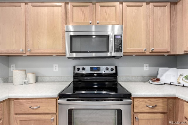 kitchen featuring stainless steel appliances and light brown cabinetry