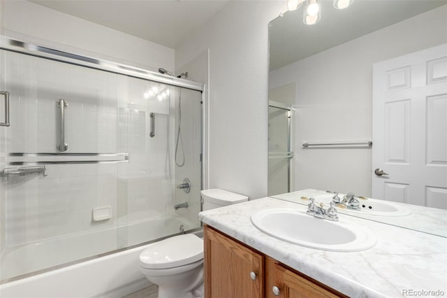 full bathroom featuring enclosed tub / shower combo, vanity, and toilet