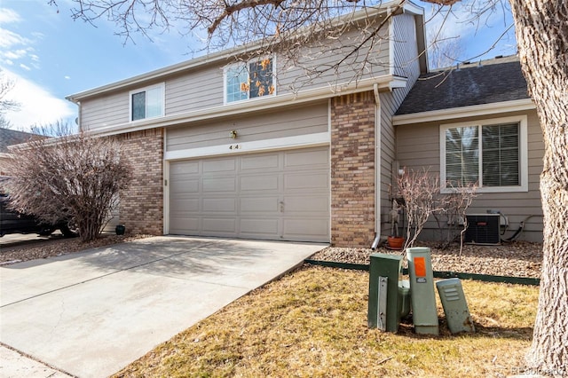 view of front of home featuring a garage, cooling unit, and a front yard