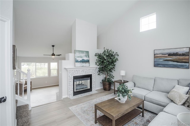 329 Lodgewood Ln, Lafayette, CO 80026 - living room with high vaulted ceiling, stairs, wood finished floors, a ceiling fan, and a tile fireplace