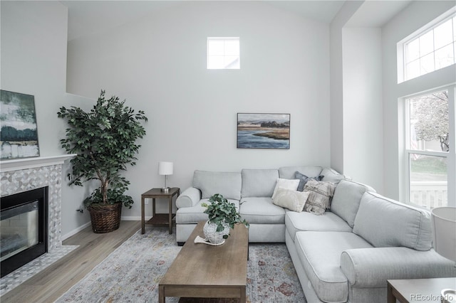 329 Lodgewood Ln, Lafayette, CO 80026 - living area featuring light wood-style flooring, high vaulted ceiling, a fireplace, and baseboards