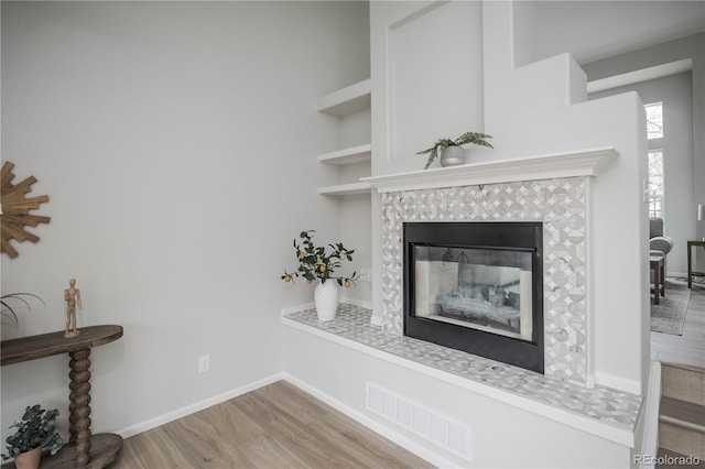 329 Lodgewood Ln, Lafayette, CO 80026 - detailed view of a tile fireplace, built in features, wood finished floors, and baseboards