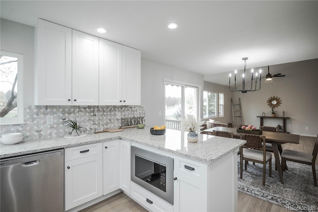 329 Lodgewood Ln, Lafayette, CO 80026 - kitchen with dishwasher, built in microwave, a peninsula, light wood-style floors, and a chandelier