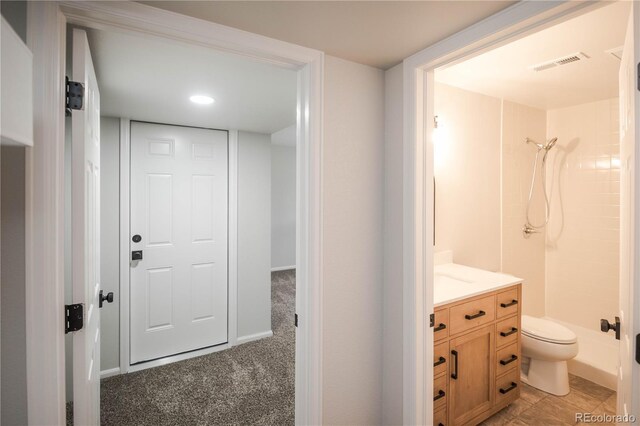 329 Lodgewood Ln, Lafayette, CO 80026 - bathroom featuring a tile shower, toilet, and vanity