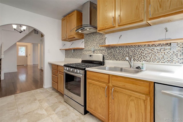 4032 Lipan St, Denver, CO 80211 - kitchen with appliances with stainless steel finishes, wall chimney range hood, arched walkways, light countertops, and backsplash