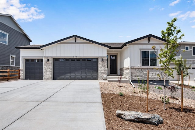 3443 N Gold Bug Ct, Aurora, CO 80019 - view of front of house featuring stone siding, a garage, board and batten siding, and concrete driveway