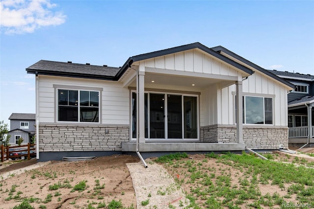 3443 N Gold Bug Ct, Aurora, CO 80019 - rear view of house with stone siding, fence, and board and batten siding