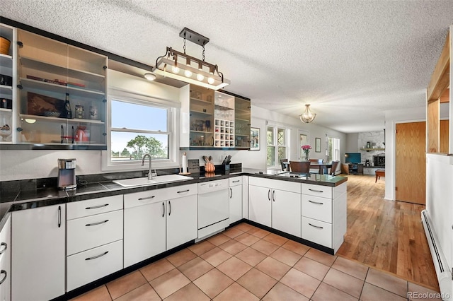 kitchen featuring a baseboard heating unit, a sink, white cabinets, dishwasher, and decorative light fixtures