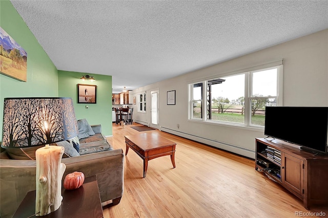 living room featuring light wood-type flooring, a textured ceiling, and baseboard heating