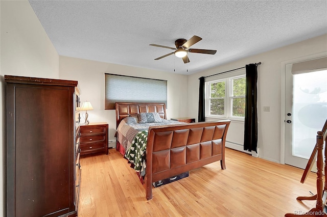 bedroom with a textured ceiling, light wood-style flooring, and a ceiling fan