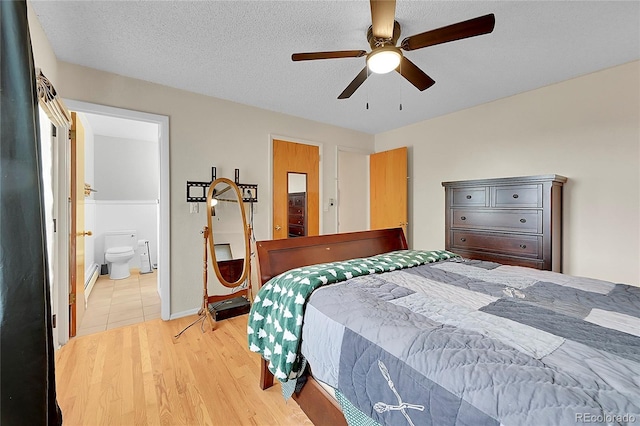 bedroom with a textured ceiling, a baseboard radiator, a ceiling fan, baseboards, and light wood-style floors