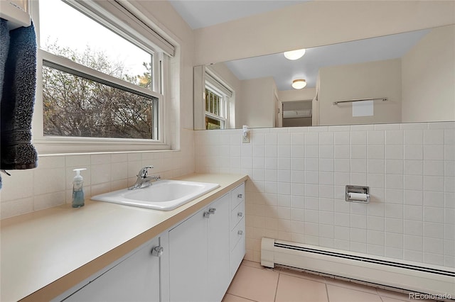 bathroom featuring tile patterned flooring, a baseboard heating unit, tile walls, and vanity