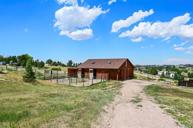 exterior space featuring an exterior structure, an outbuilding, a rural view, and a garage