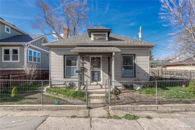 view of front of property featuring a shingled roof, a chimney, and a fenced front yard