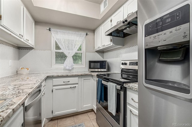 11105 E Alameda Ave Unit 204, Aurora, CO 80012 - kitchen with appliances with stainless steel finishes, under cabinet range hood, white cabinets, light tile patterned floors, and decorative backsplash