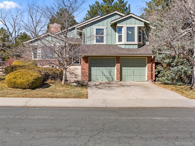 view of front of house featuring driveway, brick siding, board and batten siding, and an attached garage