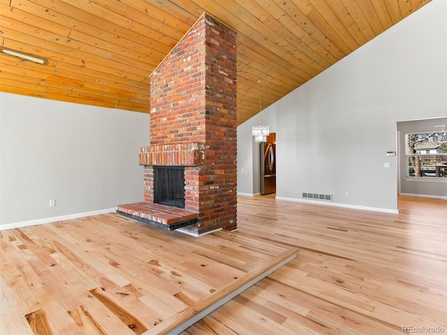 unfurnished living room featuring a fireplace, wood finished floors, visible vents, and baseboards