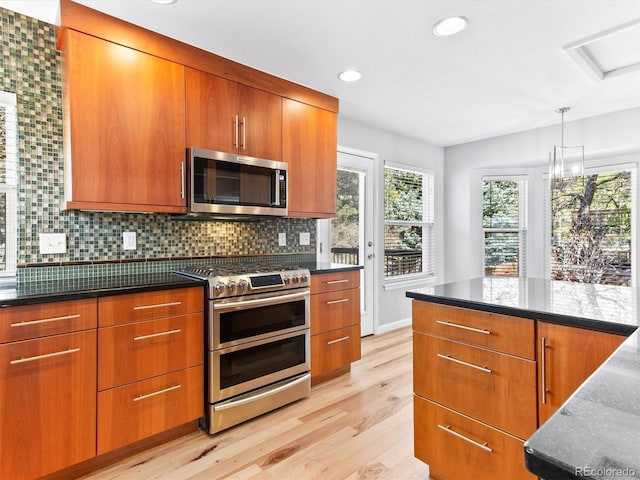 kitchen featuring appliances with stainless steel finishes, modern cabinets, brown cabinetry, and tasteful backsplash