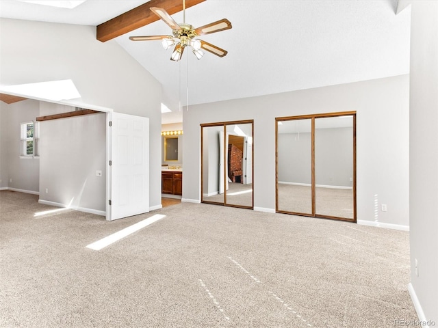 interior space with high vaulted ceiling, carpet flooring, baseboards, multiple closets, and beamed ceiling