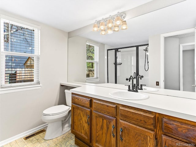 bathroom featuring visible vents, toilet, a shower stall, vanity, and baseboards