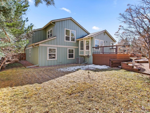 back of house with central AC, board and batten siding, a wooden deck, and fence