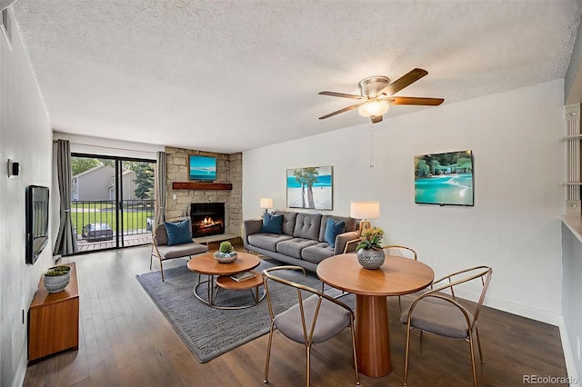 401 S Kalispell Way Unit 206, Aurora, CO 80017 - living area featuring a textured ceiling, a ceiling fan, wood finished floors, and a fireplace