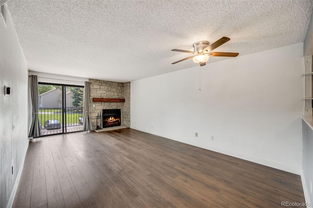 401 S Kalispell Way Unit 206, Aurora, CO 80017 - unfurnished living room featuring a textured ceiling, a ceiling fan, dark wood finished floors, and a stone fireplace