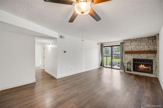 401 S Kalispell Way Unit 206, Aurora, CO 80017 - unfurnished living room featuring a textured ceiling, dark wood-style floors, a fireplace, and a ceiling fan