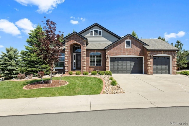 7472 Iridium Way, Castle Rock, CO 80108 - traditional home featuring an attached garage, a front yard, brick siding, and driveway