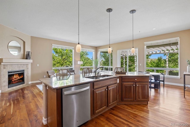 7472 Iridium Way, Castle Rock, CO 80108 - kitchen featuring dishwasher, dark wood finished floors, a fireplace, and a center island with sink