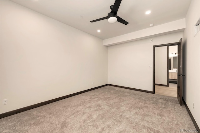 empty room featuring ceiling fan and light carpet